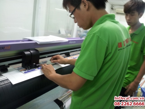 Nhân viên in ấn của In Decal - InDecal.com.vn thực hiện bế tem decal trên máy Mimaki Nhật | Loại tem nhãn decal dán tại cửa kính các cửa hàng tiện lợi, dán trên taxi